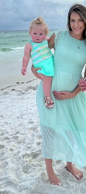 Natalie holding her daughter on the beach